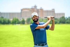 Man swinging golf club outside of Rosen Shingle Creek's Shingle Creek Golf Club, the perfect destination for a Father's Day celebration.