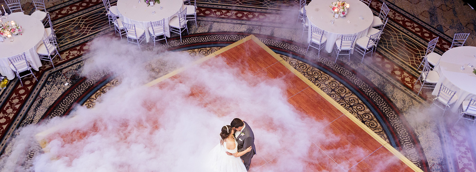 Couple dancing at wedding with smoke