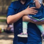 Image of a father holding his infant daughter, a perfect depiction of Father's Day.