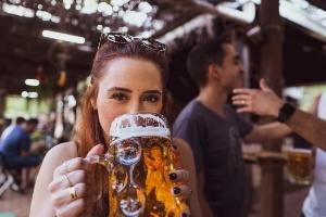 A woman drinking a beer at her local happy hour spot on I-Drive.