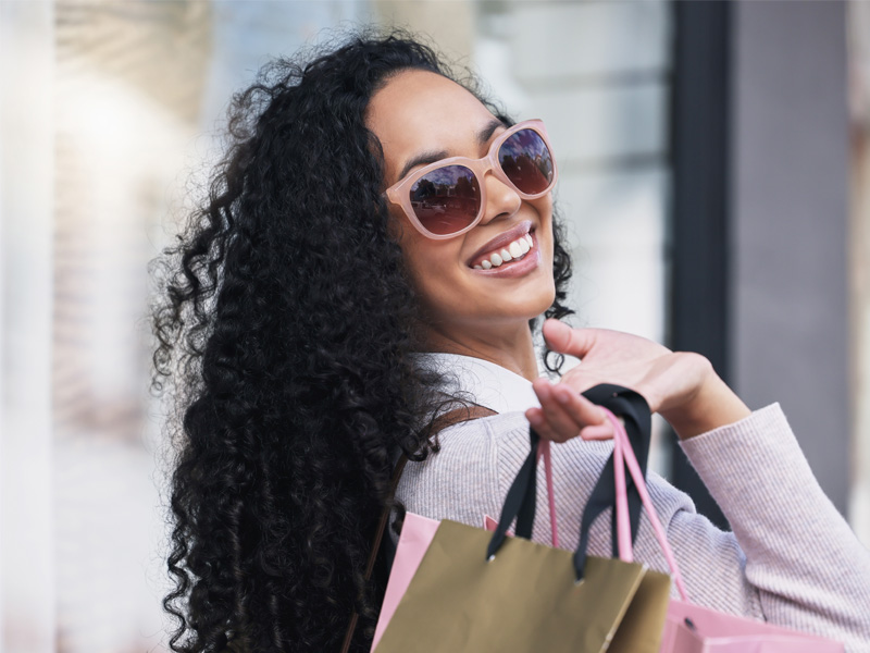 Woman in sunglasses with shopping bags